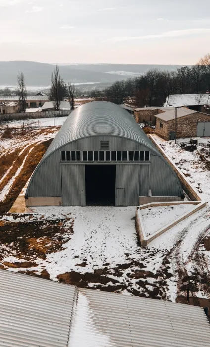 Hangar metalic semirotund iarna, cu zăpadă