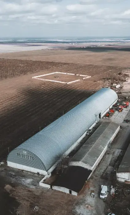 Hangar semirotund lung lângă o fermă, văzut de sus