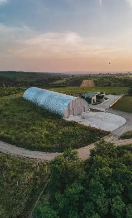 Vedere aeriană a unui hangar semirotund lângă pădure