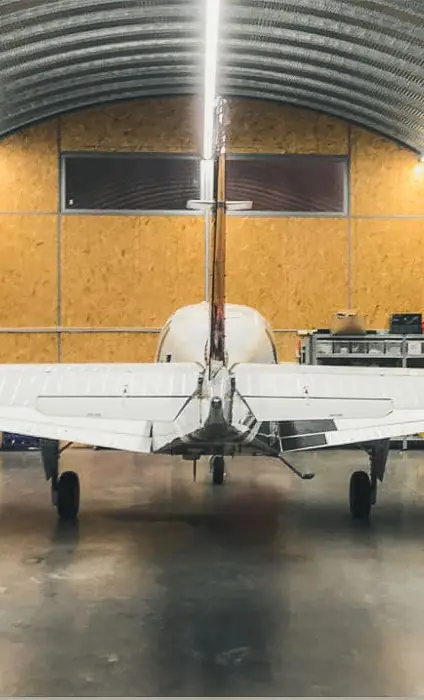 Avion în interiorul unui hangar metalic semirotund
